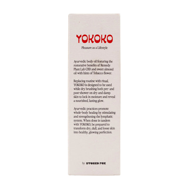Yokoko Ayurvedic CBD infused Body Oil held in hand by male model under clear blue skies.