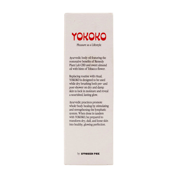 Yokoko Ayurvedic CBD infused Body Oil held in hand by male model under clear blue skies. 